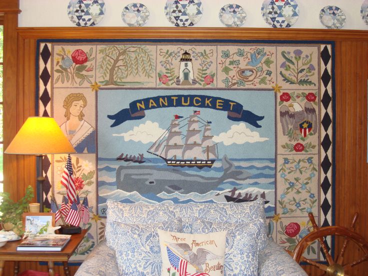 Decorative tapestry with Nantucket theme in a room with a lamp and pillows.