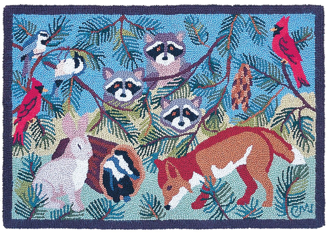 A rectangular rug with an artistic depiction of various forest animals including a rabbit, raccoon, and fox, surrounded by pine branches and a blue sky.