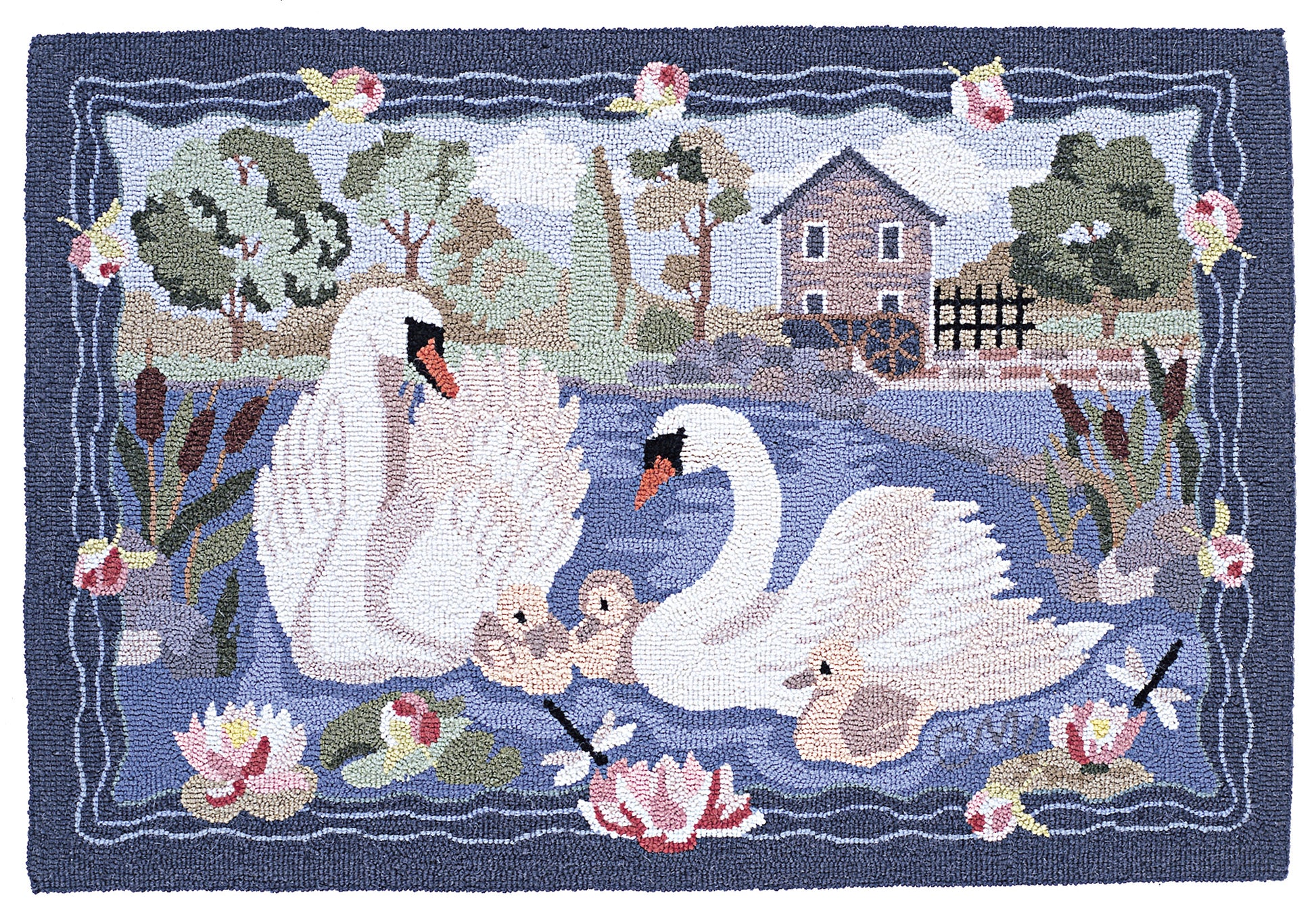 A hand-hooked rug featuring a family of white swans, two cygnets, reeds, water lilies, a small house, and a water wheel by a blue pond, bordered by a dark blue frame with pink flowers.