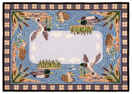 A rectangular hand-hooked area rug featuring a nature pond scene with mallards, ducks, reeds, and a plaid border. The center is is light blue with clouds.
