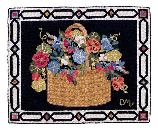 A square hand-hooked  rug featuring a woven basket overflowing with colorful flowers, set against a black background and framed by a decorative geometric border in white, black, and small red, blue, and gold accents.