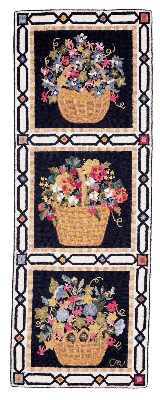 A hand-hooked runner featuring three stacked baskets of colorful wildflowers on a black background, framed by a geometric border with beige, black, and small red accents.